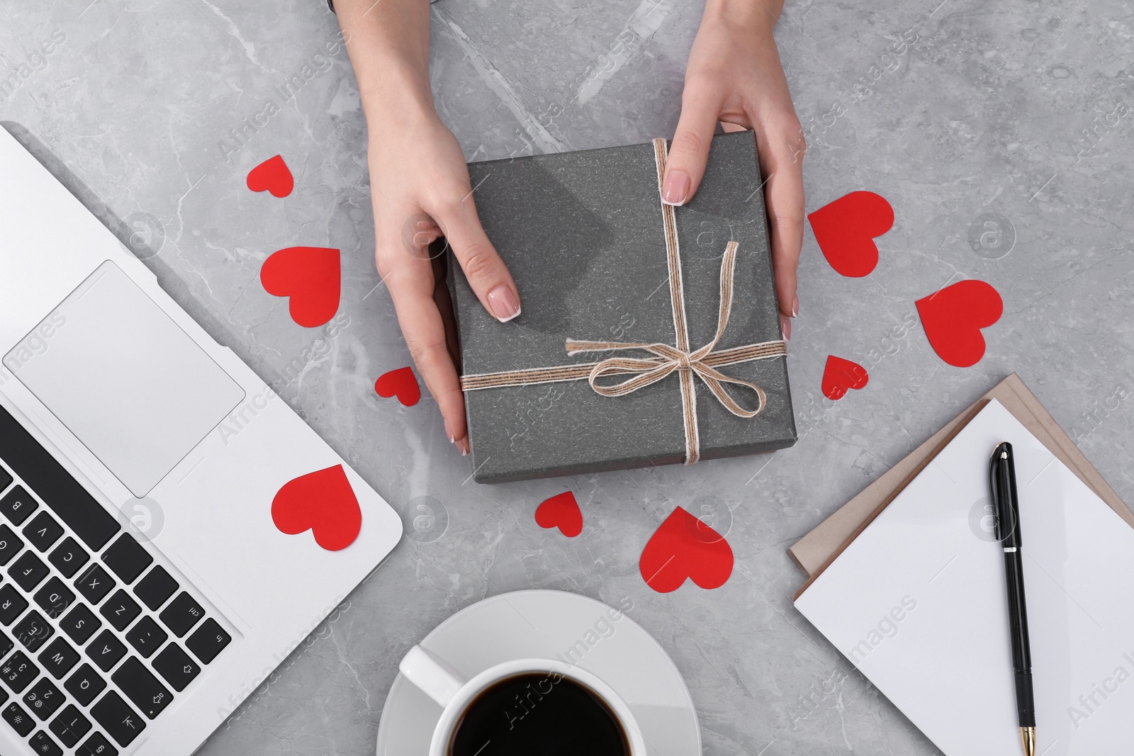 Woman with gift box at light grey marble table, flat lay. Valentine's day celebration Photo of Woman with gift box at light grey marble table, flat lay. Valentine's day celebration