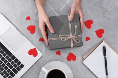 Woman with gift box at light grey marble table, flat lay. Valentine's day celebration Photo of Woman with gift box at light grey marble table, flat lay. Valentine's day celebration