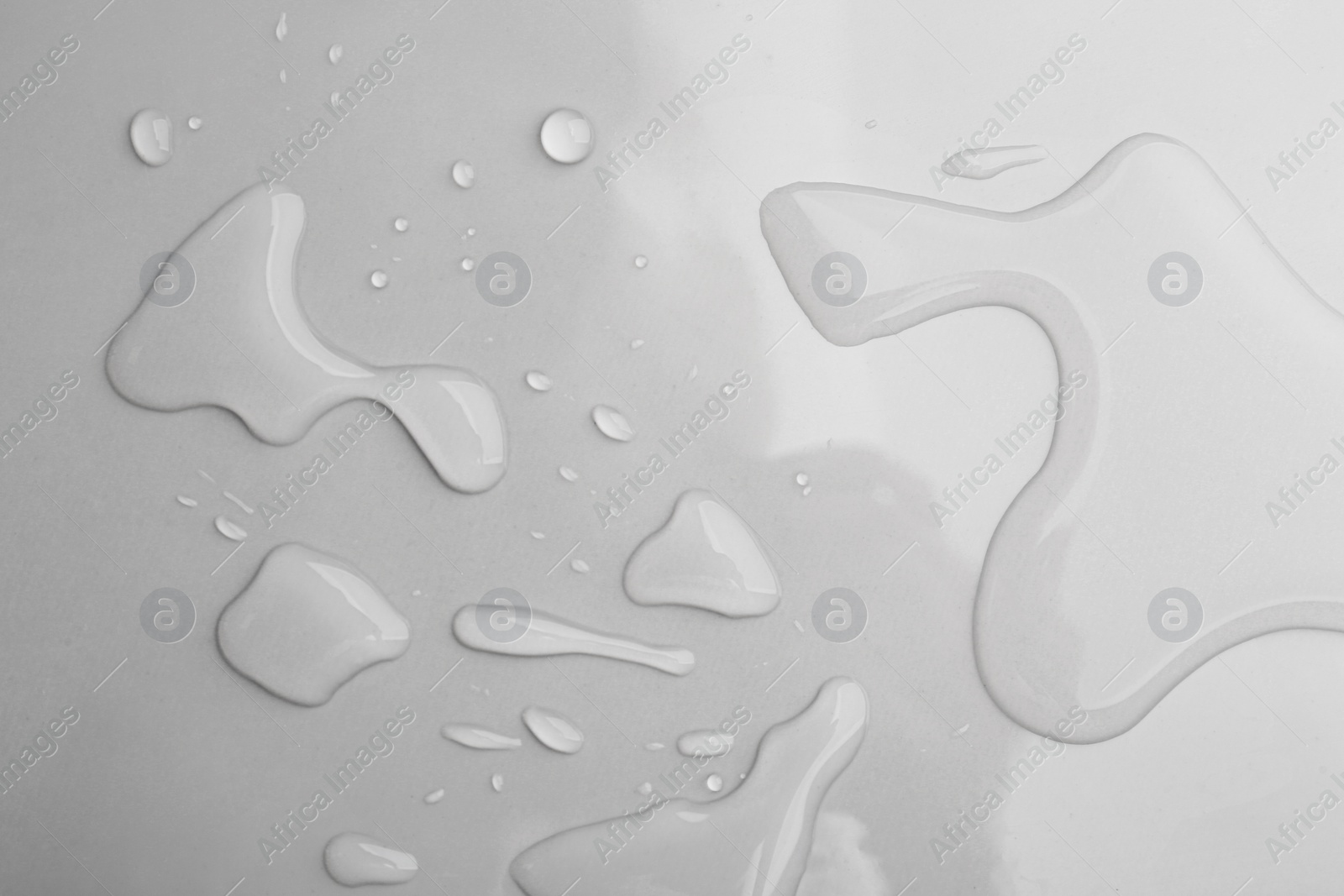 Drops of spilled water on grey background, top view Photo of Drops of spilled water on grey background, top view