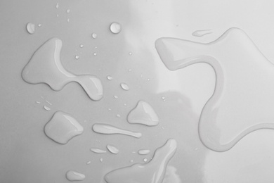 Drops of spilled water on grey background, top view Photo of Drops of spilled water on grey background, top view