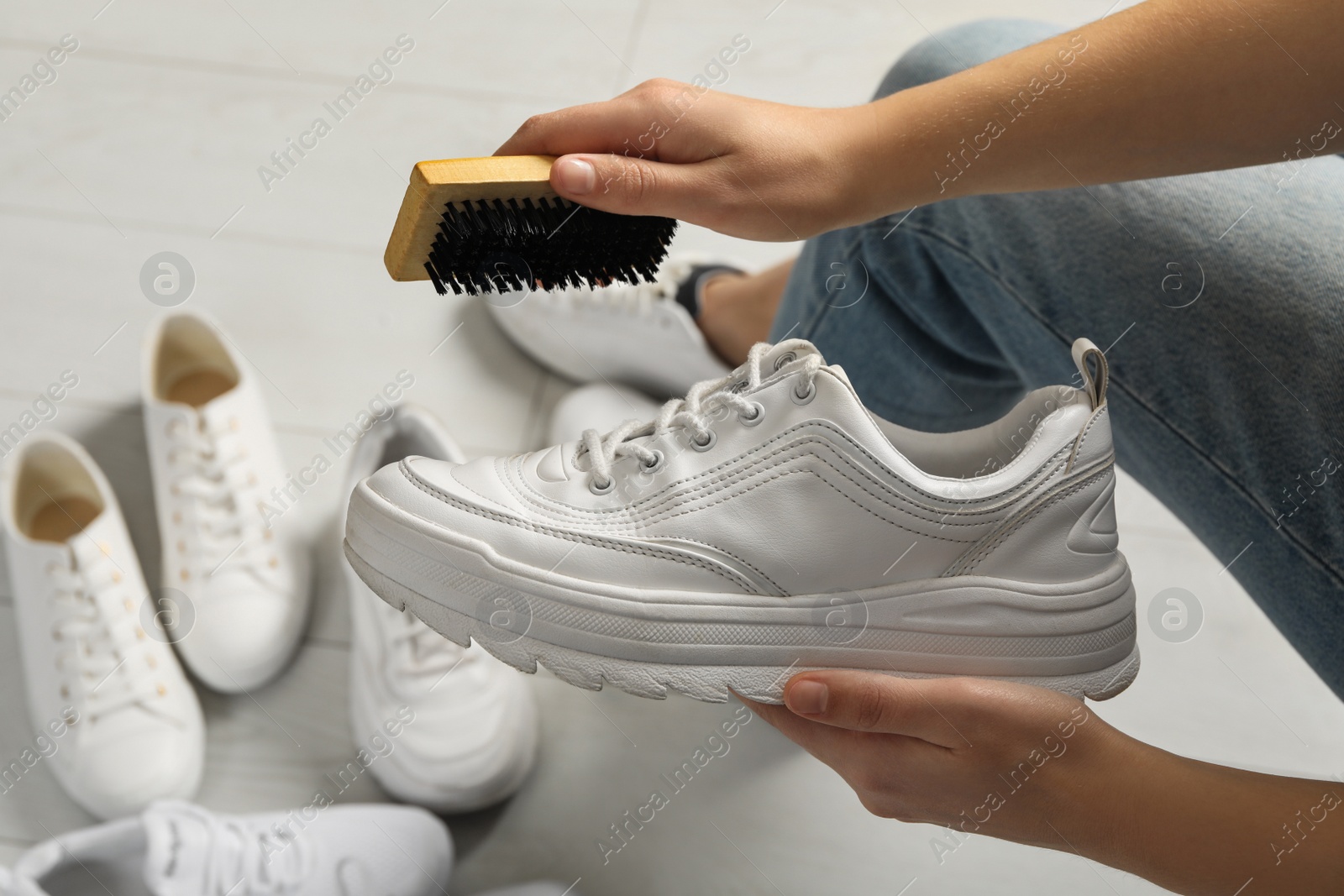Woman cleaning stylish footwear indoors, closeup. Shoe care accessory Photo of Woman cleaning stylish footwear indoors, closeup. Shoe care accessory