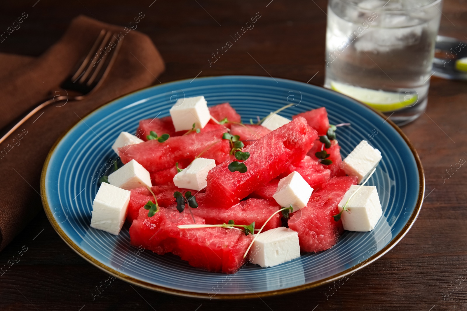 Delicious salad with watermelon and feta cheese on wooden table, closeup Photo of Delicious salad with watermelon and feta cheese on wooden table, closeup