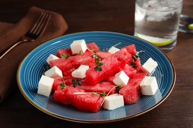 Delicious salad with watermelon and feta cheese on wooden table, closeup Photo of Delicious salad with watermelon and feta cheese on wooden table, closeup