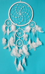 Beautiful dream catcher hanging on light blue background Photo of Beautiful dream catcher hanging on light blue background