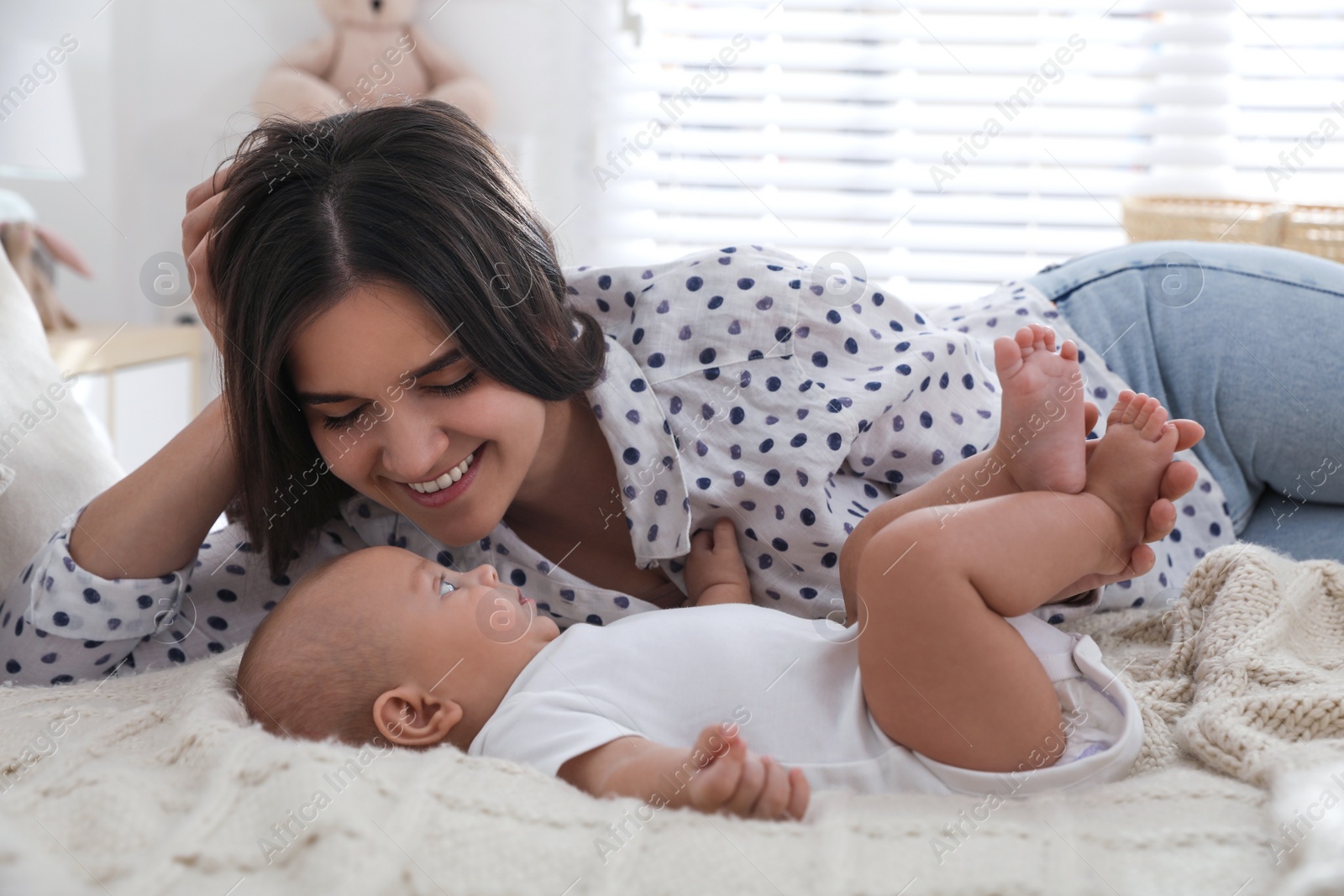 Mother with her cute baby on bed at home Photo of Mother with her cute baby on bed at home