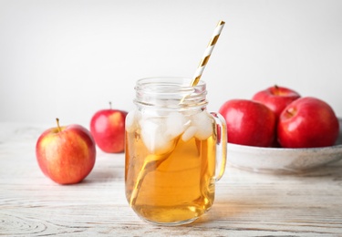 Mason jar with fresh apple juice on wooden table Photo of Mason jar with fresh apple juice on wooden table