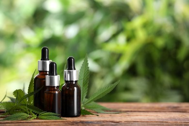 Hemp leaves, bottles of CBD oil and THC tincture on wooden table. Space for text Photo of Hemp leaves, bottles of CBD oil and THC tincture on wooden table. Space for text