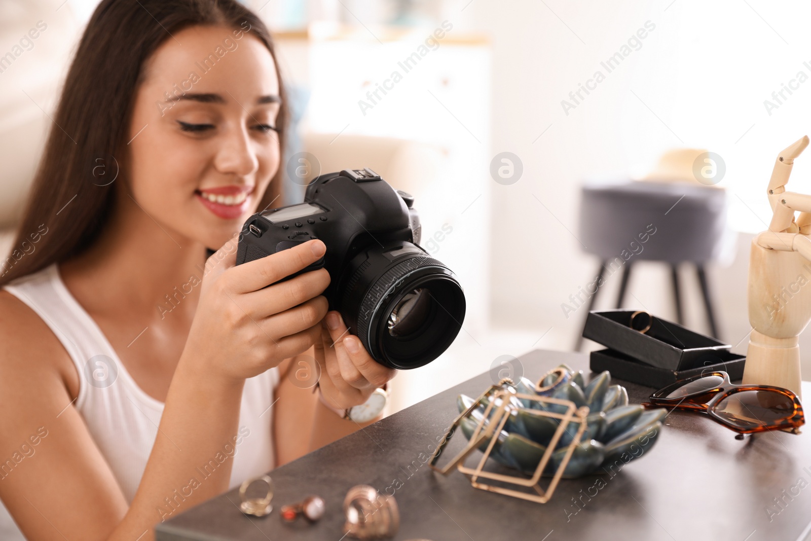 Young photographer taking picture of jewelry indoors, closeup Photo of Young photographer taking picture of jewelry indoors, closeup