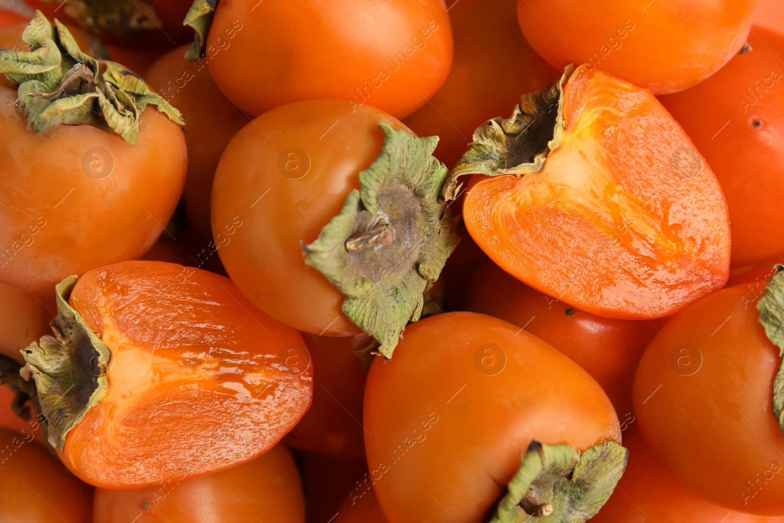 Tasty fresh ripe persimmons as background, closeup Photo of Tasty fresh ripe persimmons as background, closeup