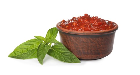 Delicious adjika sauce in bowl and basil isolated on white Photo of Delicious adjika sauce in bowl and basil isolated on white