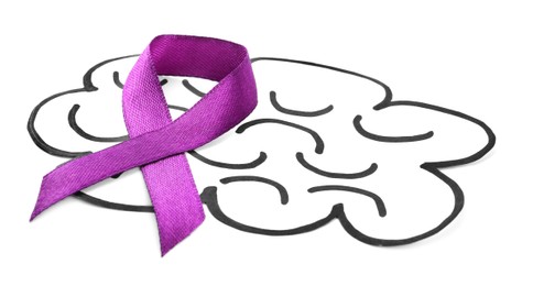 Paper brain cutout with purple ribbon on white background Photo of Paper brain cutout with purple ribbon on white background