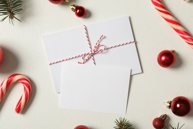 Flat lay composition with blank greeting cards and Christmas decor on white background, space for text Photo of Flat lay composition with blank greeting cards and Christmas decor on white background, space for text