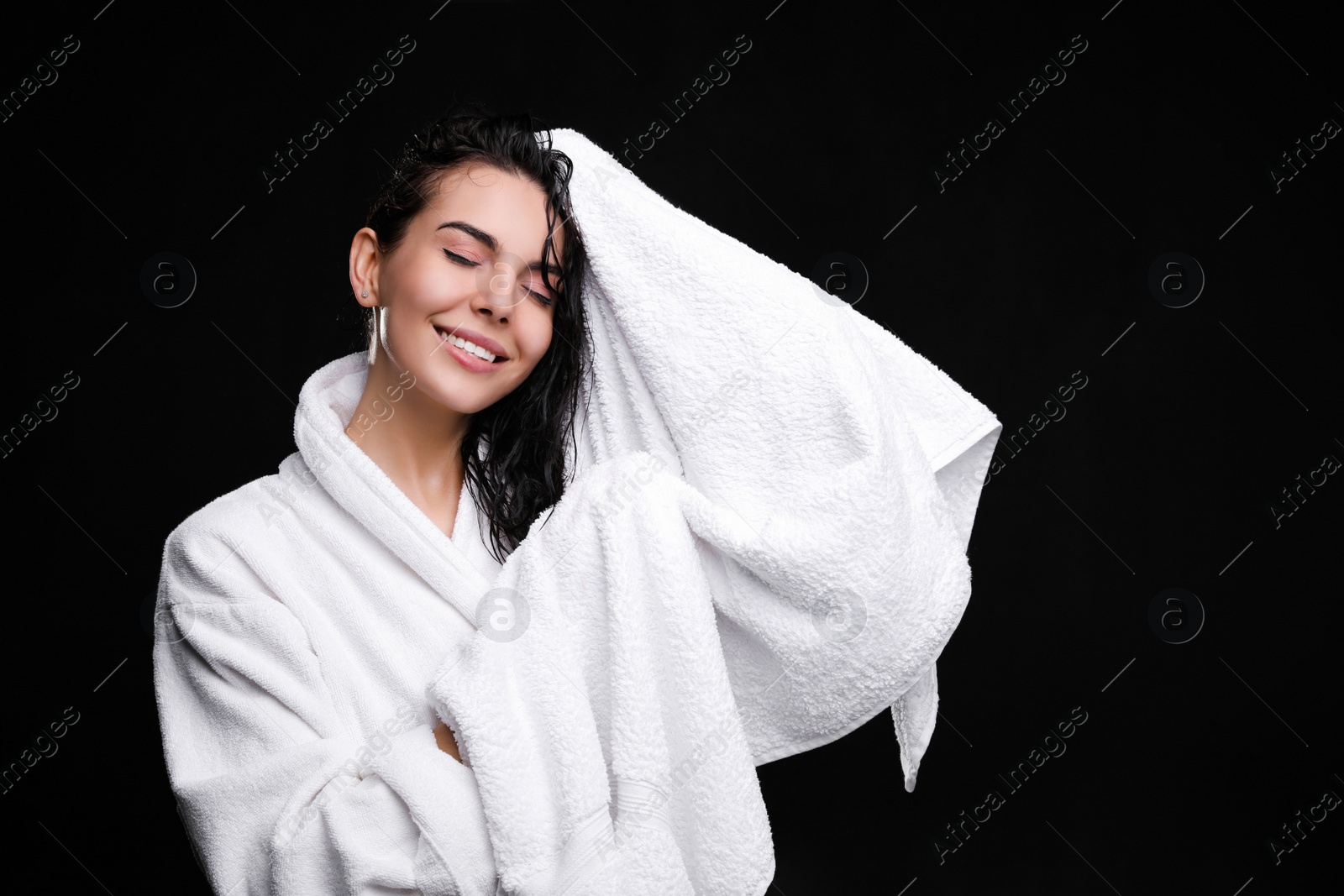 Pretty woman drying hair with towel after washing on black background Photo of Pretty woman drying hair with towel after washing on black background