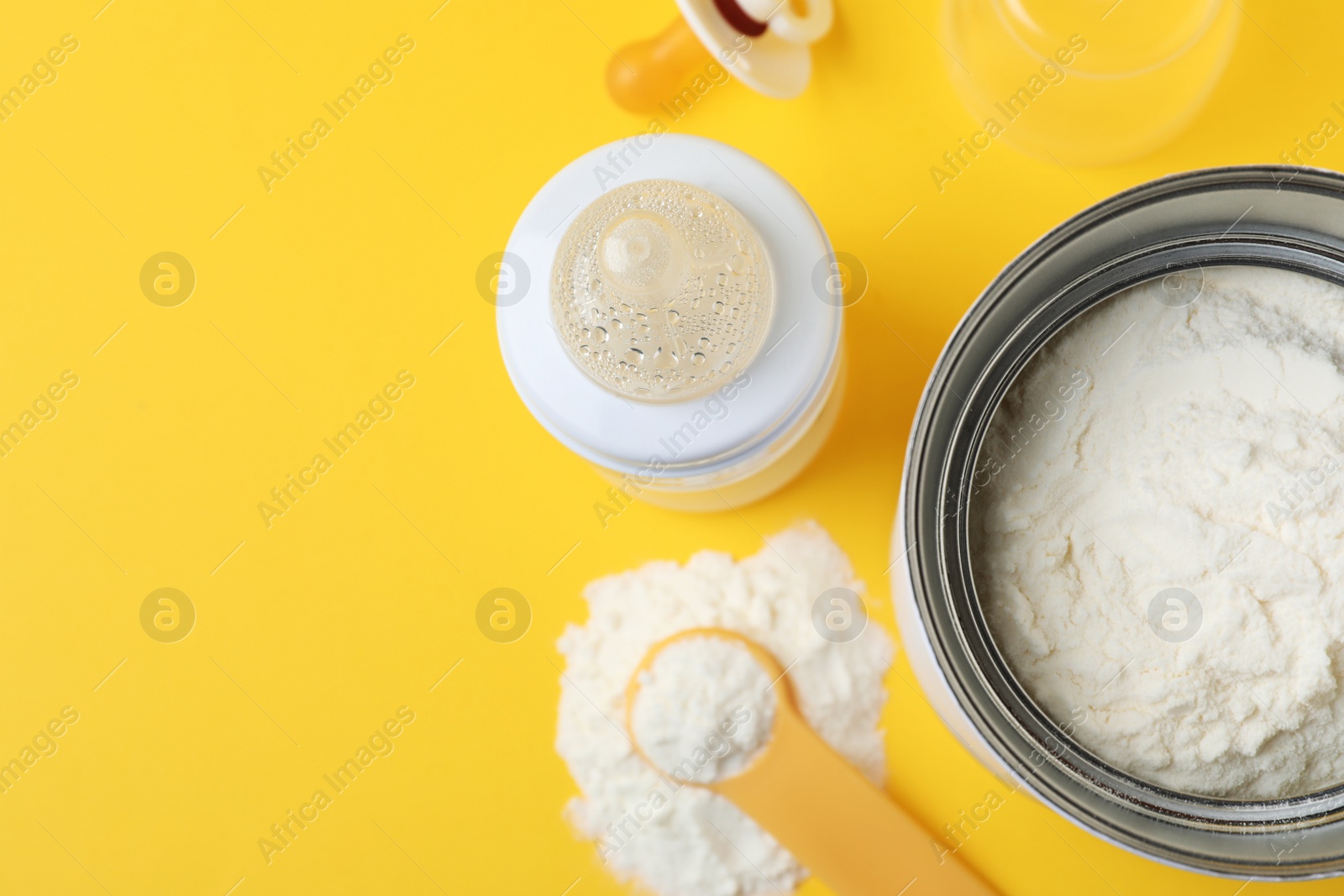 Flat lay composition with powdered infant formula on yellow background, space for text. Baby milk Photo of Flat lay composition with powdered infant formula on yellow background, space for text. Baby milk