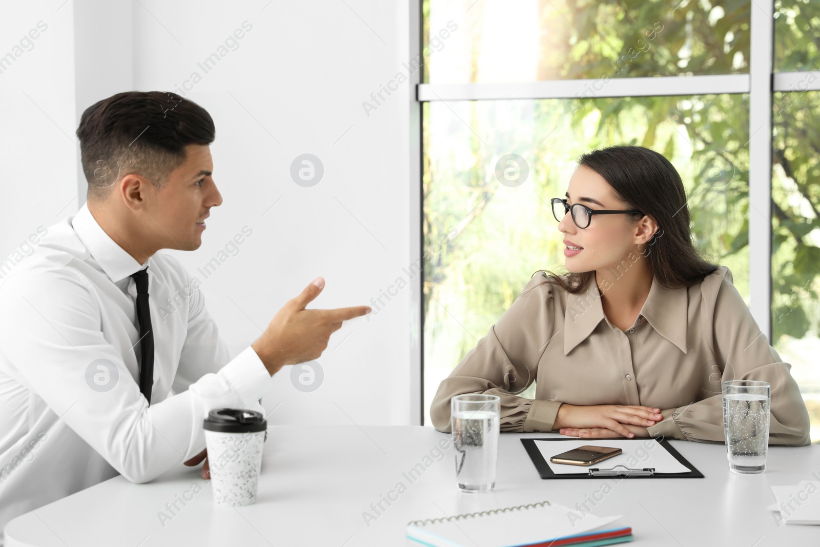 Photo of Office employees talking at table during meeting