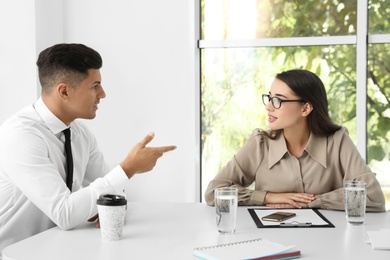 Office employees talking at table during meeting Photo of Office employees talking at table during meeting