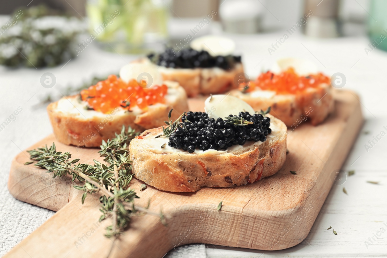 Sandwiches with black and red caviar on wooden board Photo of Sandwiches with black and red caviar on wooden board
