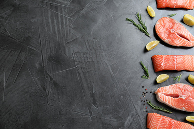 Flat lay composition with fresh raw salmon, rosemary and lemon on dark grey table, space for text. Fish delicacy Photo of Flat lay composition with fresh raw salmon, rosemary and lemon on dark grey table, space for text. Fish delicacy