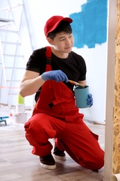 Male decorator painting wall with brush indoors Photo of Male decorator painting wall with brush indoors