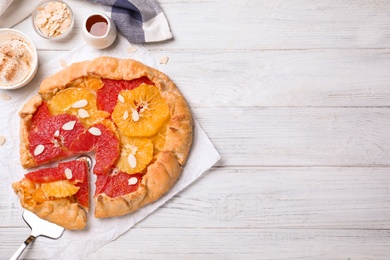Tasty galette with citrus fruits served on white wooden table, flat lay. Space for text Photo of Tasty galette with citrus fruits served on white wooden table, flat lay. Space for text