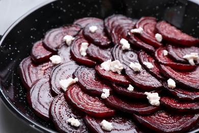 Roasted beetroot slices with feta cheese in wok pan, closeup Photo of Roasted beetroot slices with feta cheese in wok pan, closeup