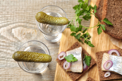 Cold Russian vodka with pickles on table, flat lay Photo of Cold Russian vodka with pickles on table, flat lay