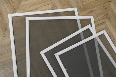 Set of window screens on wooden floor, flat lay Photo of Set of window screens on wooden floor, flat lay