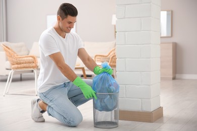 Man taking garbage bag out of bin at home Photo of Man taking garbage bag out of bin at home