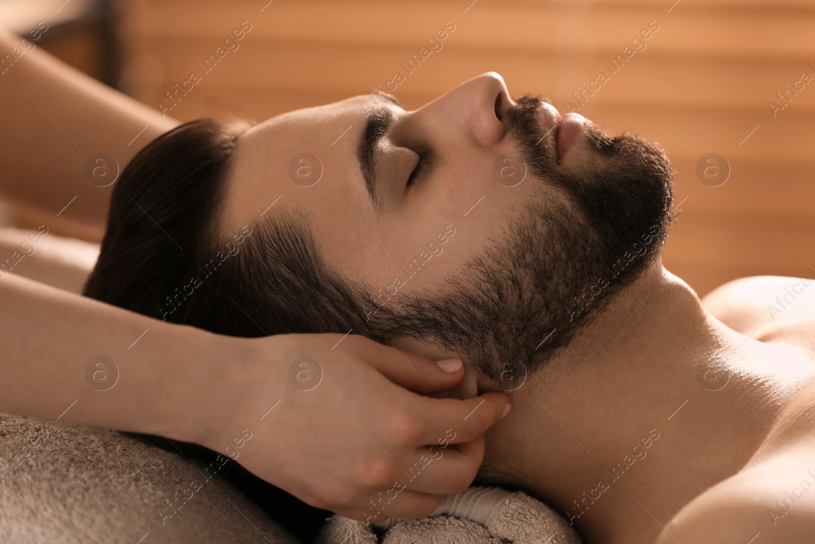 Young man receiving facial massage in beauty salon, closeup Photo of Young man receiving facial massage in beauty salon, closeup