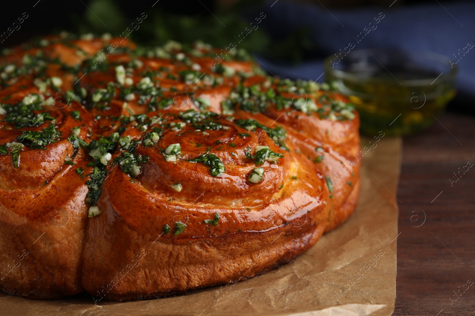 Traditional Ukrainian garlic bread with herbs (Pampushky) on wooden table, closeup Photo of Traditional Ukrainian garlic bread with herbs (Pampushky) on wooden table, closeup