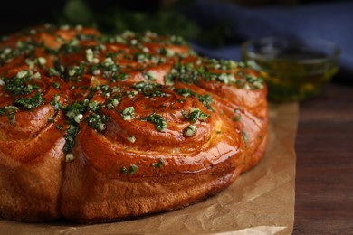 Traditional Ukrainian garlic bread with herbs (Pampushky) on wooden table, closeup Photo of Traditional Ukrainian garlic bread with herbs (Pampushky) on wooden table, closeup