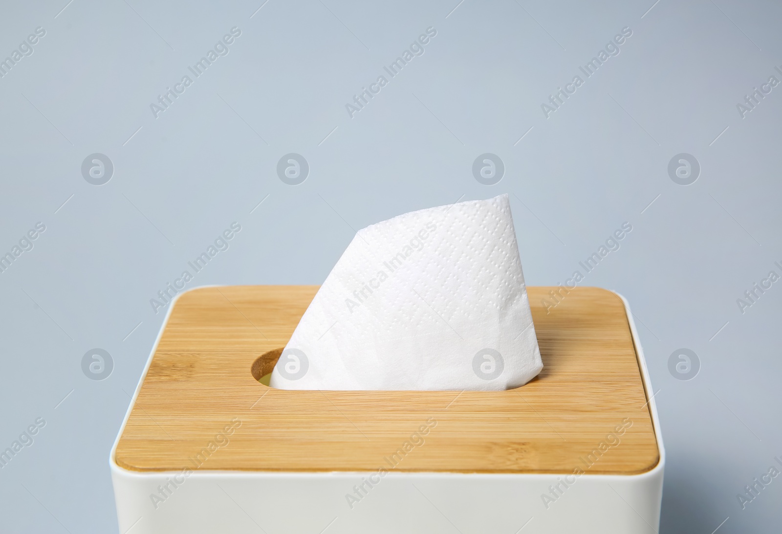 Holder with paper tissues on light grey background, closeup Photo of Holder with paper tissues on light grey background, closeup