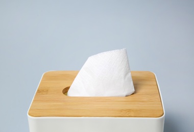 Holder with paper tissues on light grey background, closeup Photo of Holder with paper tissues on light grey background, closeup