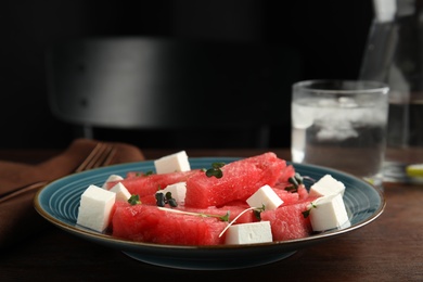 Delicious salad with watermelon and cheese on wooden table, closeup Photo of Delicious salad with watermelon and cheese on wooden table, closeup