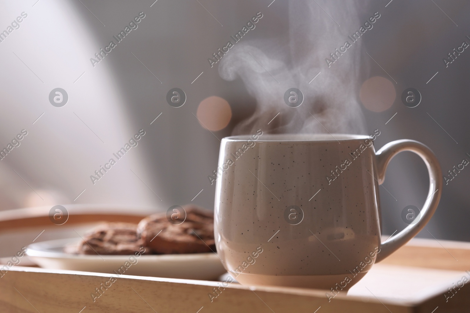 Cup of hot drink on wooden tray against blurred background, closeup Photo of Cup of hot drink on wooden tray against blurred background, closeup