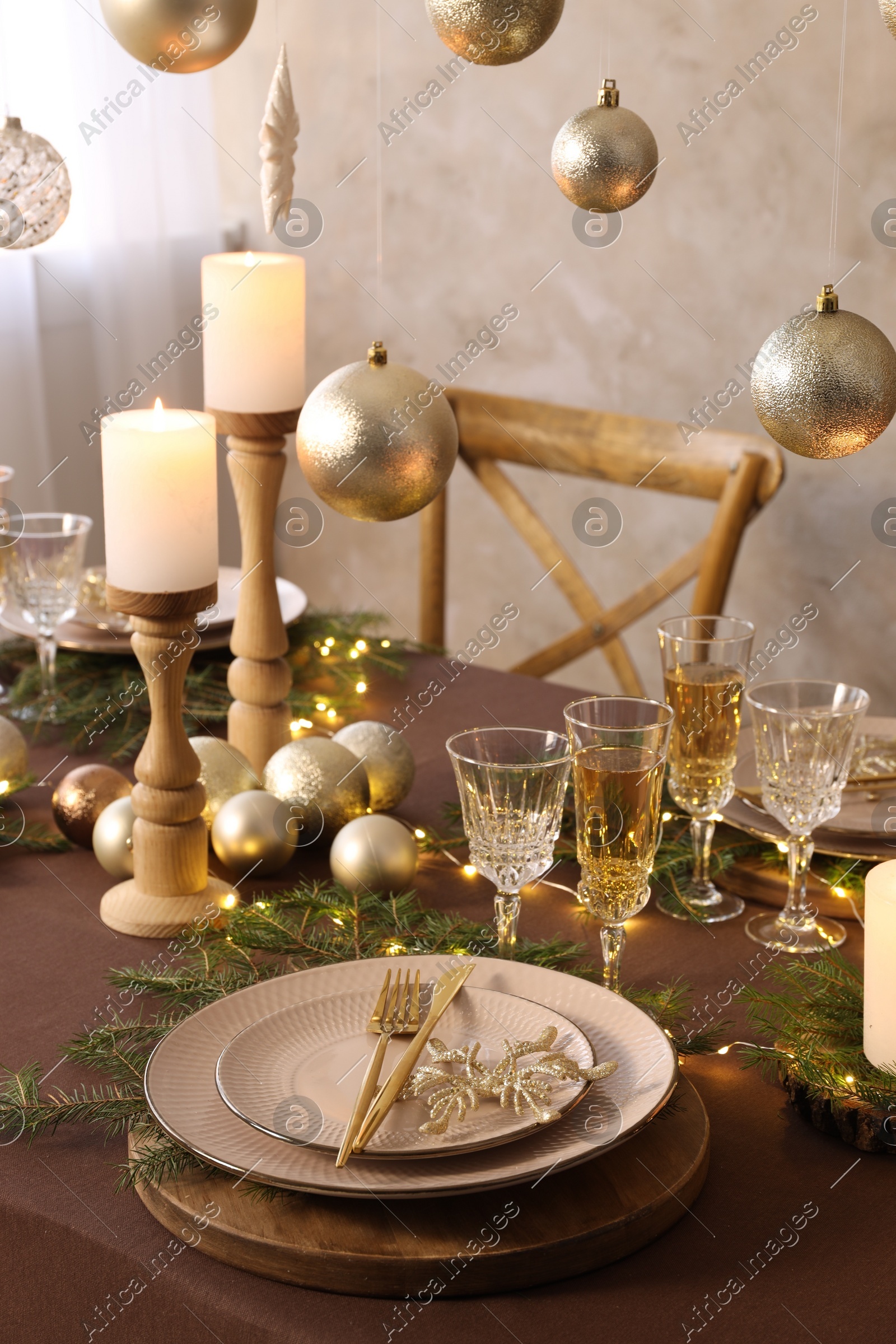 Christmas table setting with burning candles and festive decor Photo of Christmas table setting with burning candles and festive decor