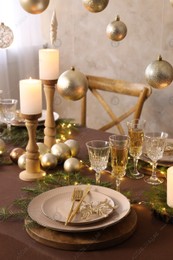 Christmas table setting with burning candles and festive decor Photo of Christmas table setting with burning candles and festive decor