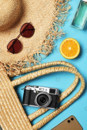 Flat lay composition with wicker bag and other beach accessories on light blue background Photo of Flat lay composition with wicker bag and other beach accessories on light blue background