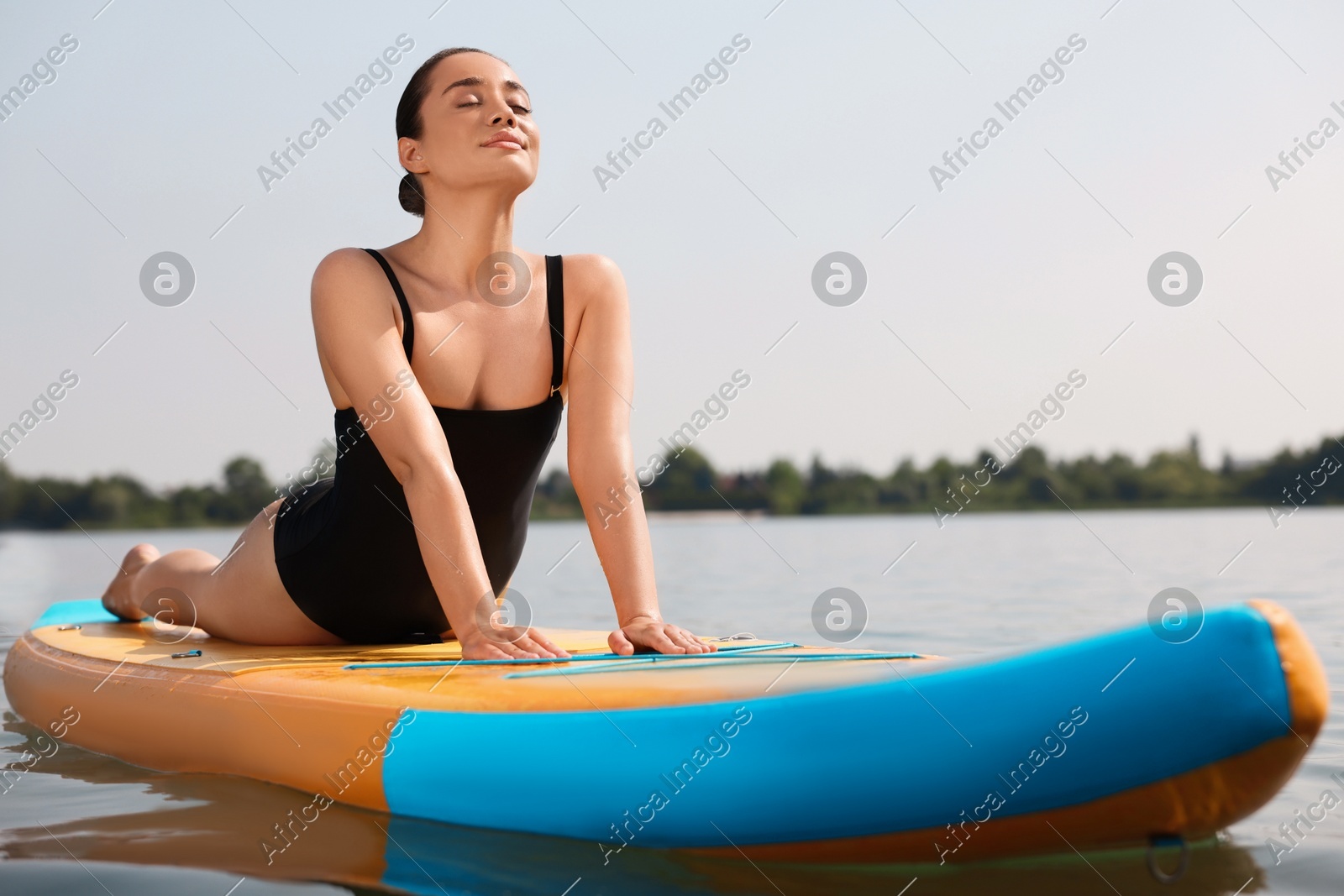 Woman practicing yoga on SUP board on river Photo of Woman practicing yoga on SUP board on river
