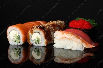 Set of delicious sushi on black mirror surface Photo of Set of delicious sushi on black mirror surface