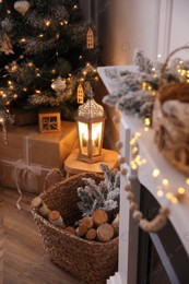Basket with wood near fireplace and Christmas tree indoors. Interior element Photo of Basket with wood near fireplace and Christmas tree indoors. Interior element