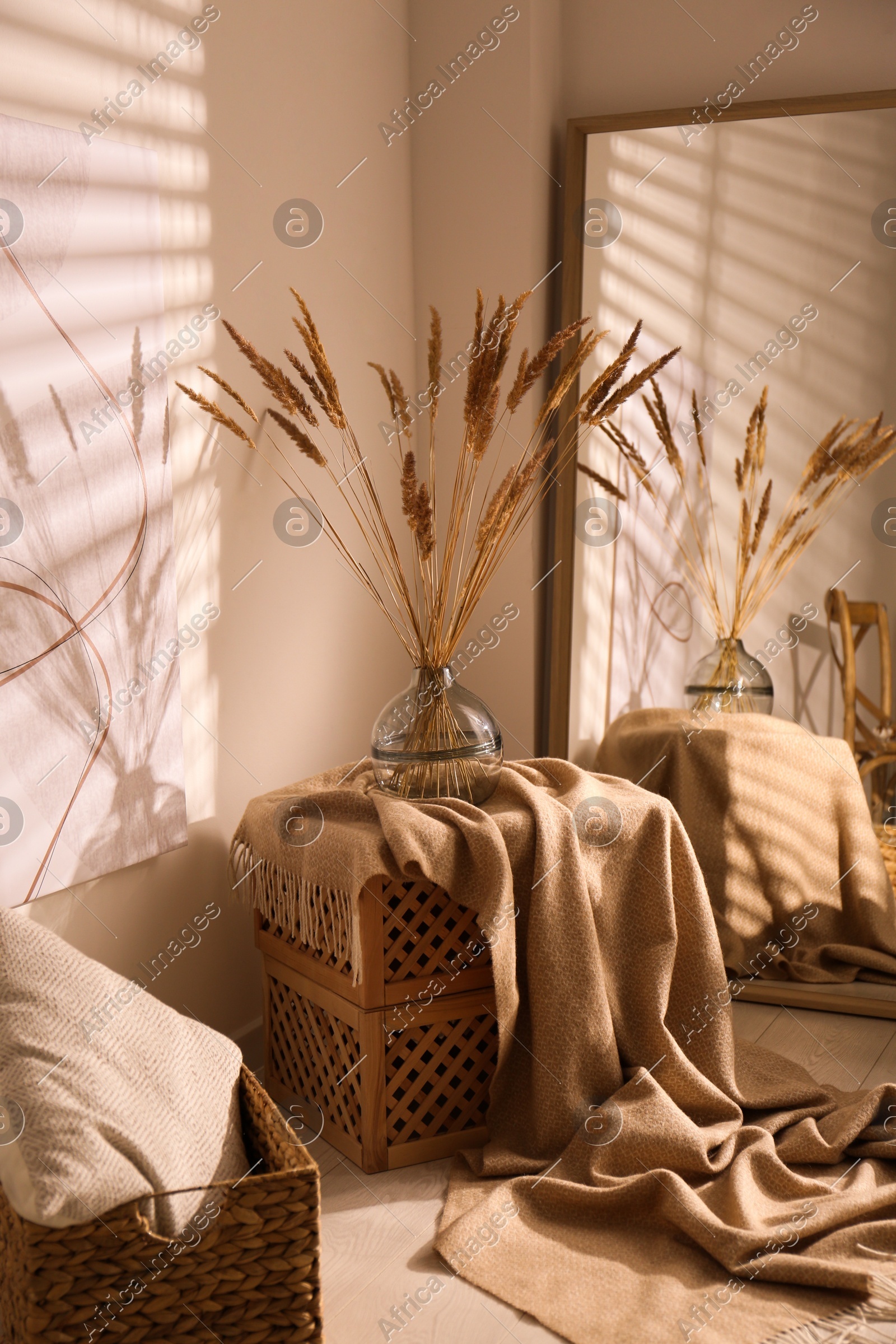 Vase with decorative dried plants and painting in stylish room interior Photo of Vase with decorative dried plants and painting in stylish room interior