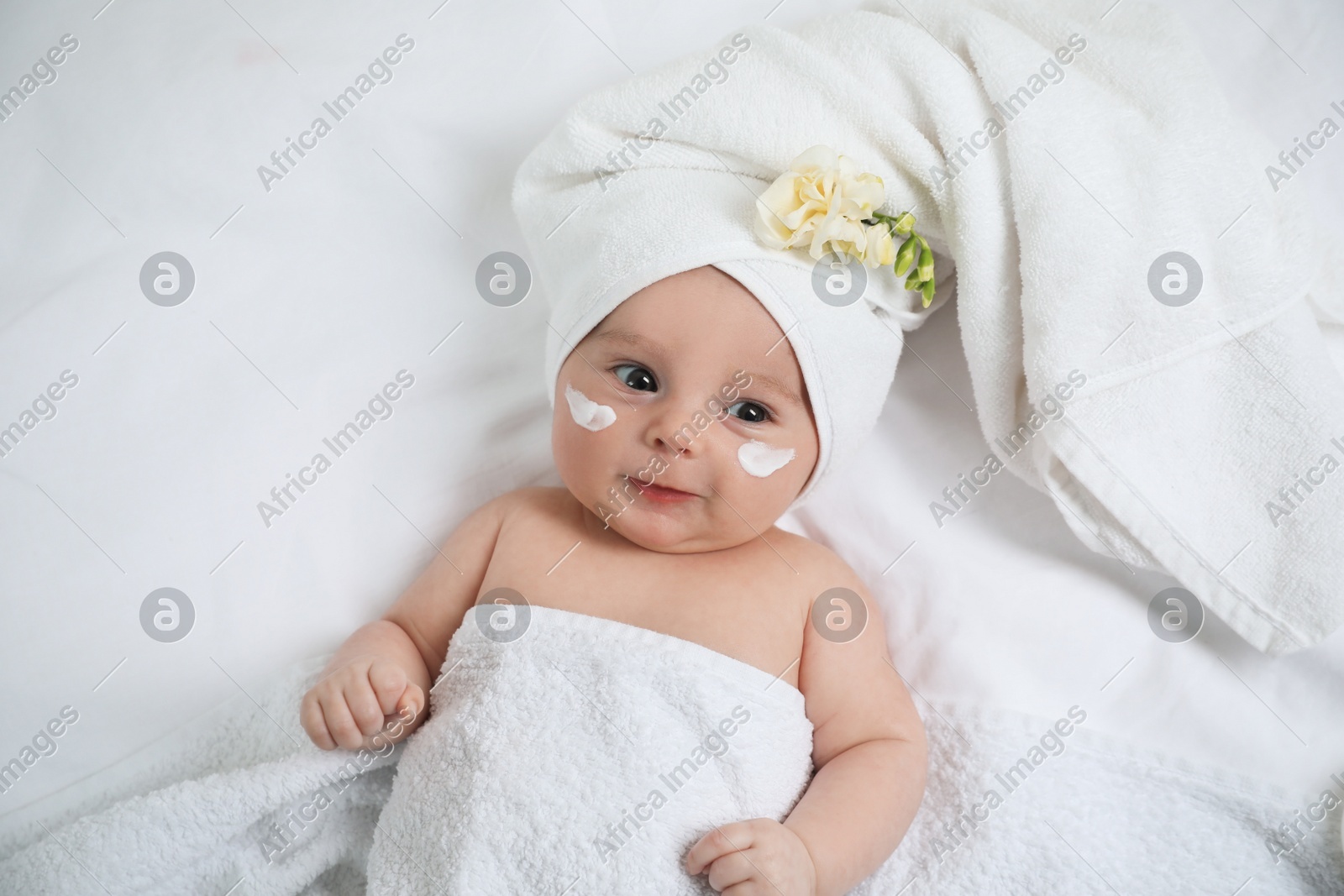 Cute little baby with cream on face, top view Photo of Cute little baby with cream on face, top view