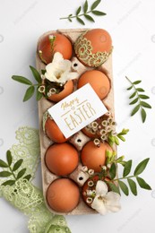 Card with words Happy Easter, eggs and green twigs on white background, flat lay Photo of Card with words Happy Easter, eggs and green twigs on white background, flat lay