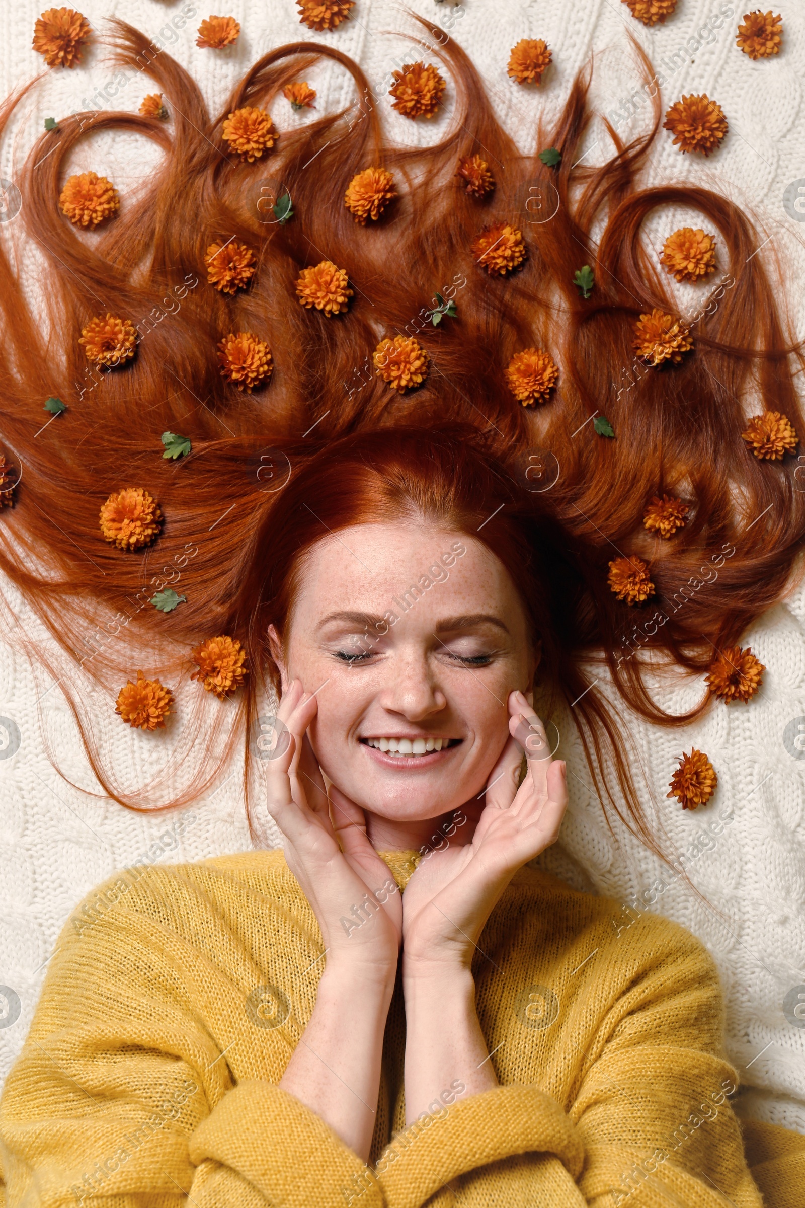 Beautiful redhead woman with flowers in hair lying on white plaid, top view Photo of Beautiful redhead woman with flowers in hair lying on white plaid, top view
