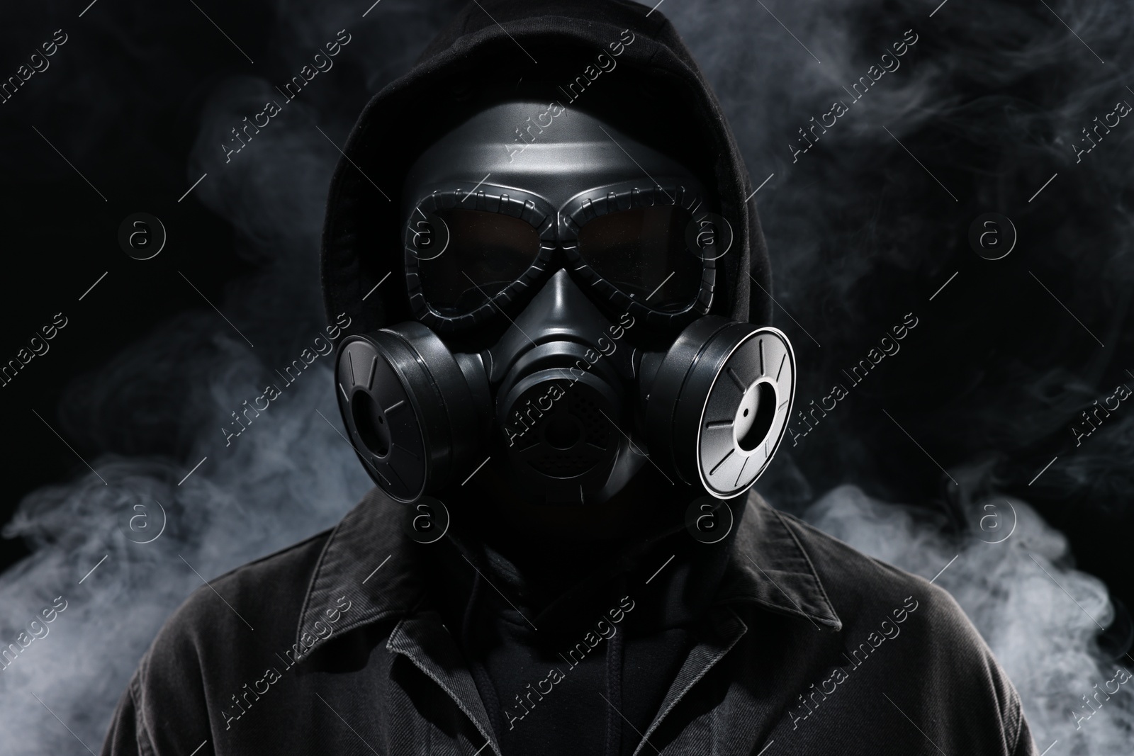 Man wearing gas mask in smoke on black background Photo of Man wearing gas mask in smoke on black background