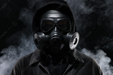 Man wearing gas mask in smoke on black background Photo of Man wearing gas mask in smoke on black background