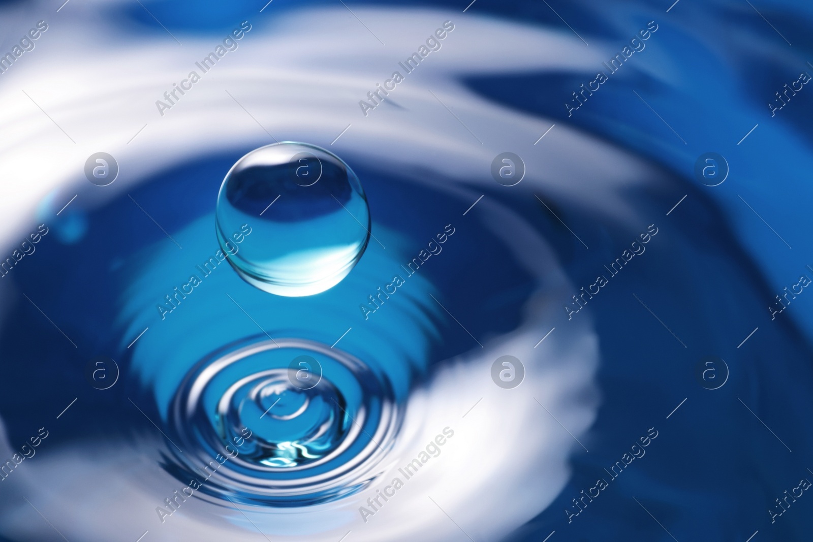 Splash of clear water with drop on blue background, closeup Photo of Splash of clear water with drop on blue background, closeup