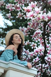Photo of Beautiful woman near blossoming magnolia tree on spring day