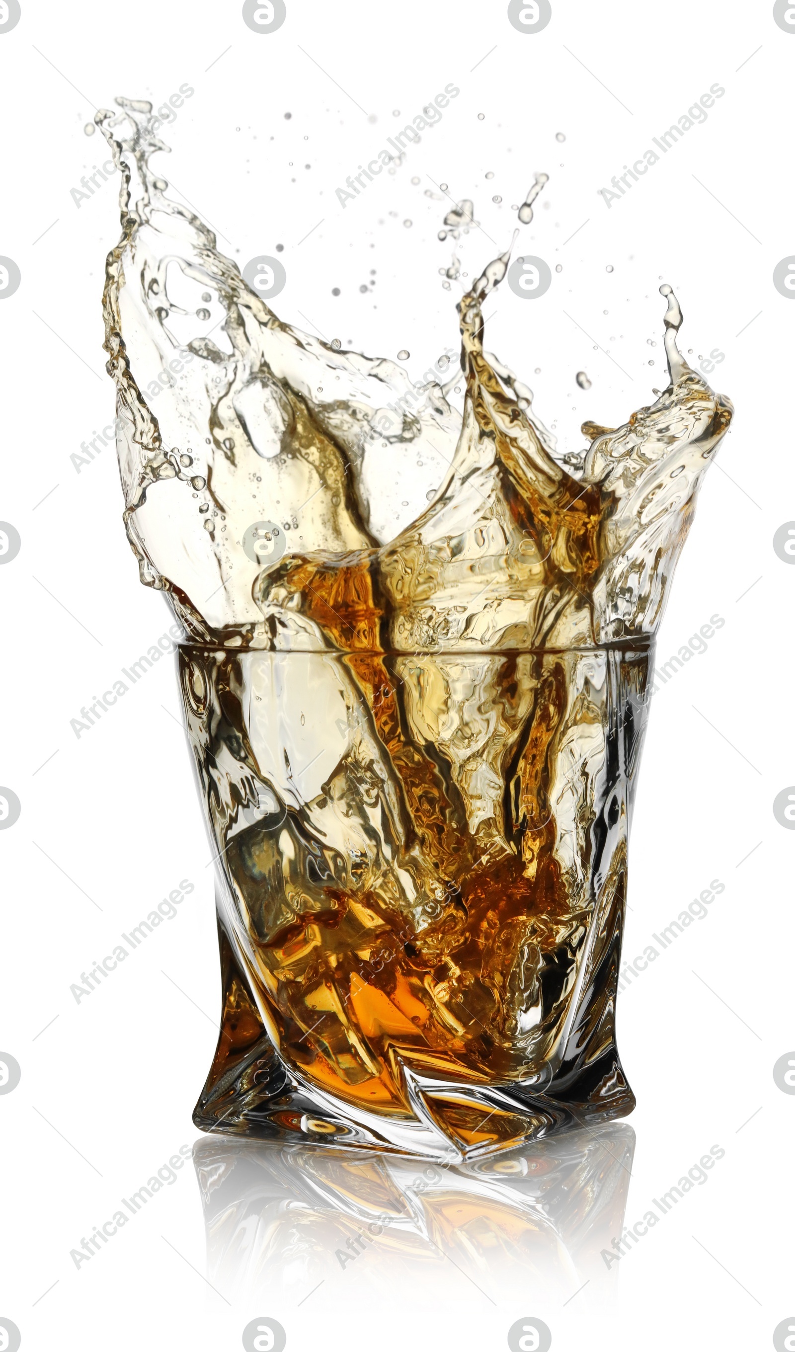 Whiskey splashing out of glass on white background Photo of Whiskey splashing out of glass on white background